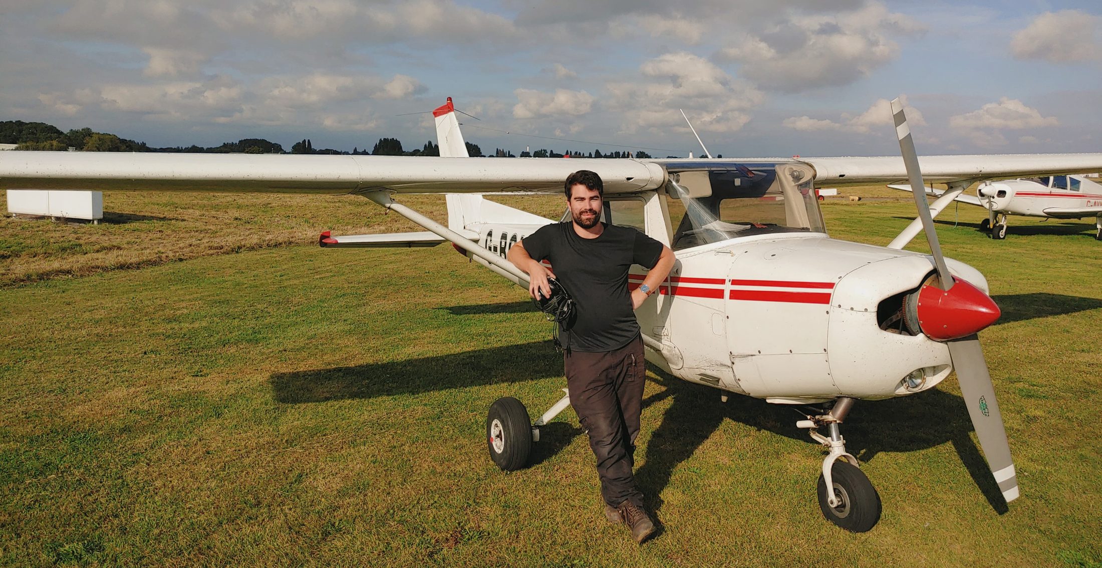 Alex Pink beside a light aircraft